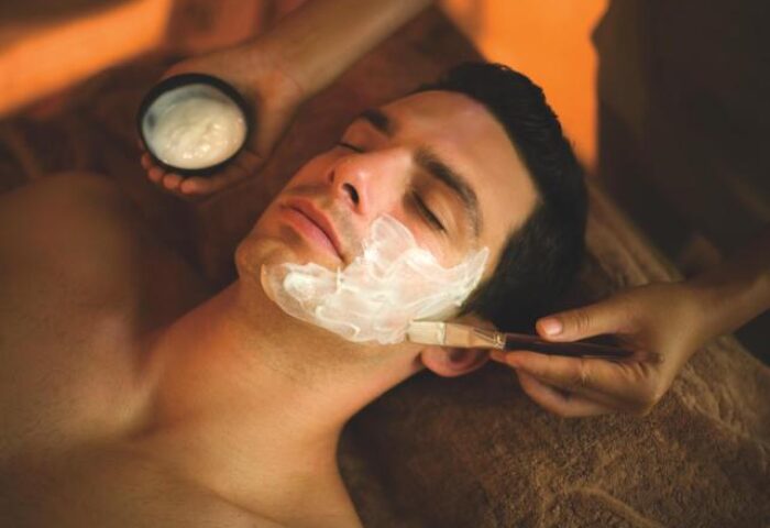 Gay-Friendly Rayavadee Hotel: Man receiving facial treatment with cream applied by brush. Spa day at luxury hotel for gay men.
