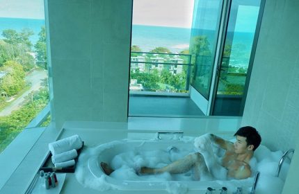 Man in bubble bath at Gay-Friendly Rayong Marriott Resort & Spa. Ocean view from hotel room. Thailand travel for gay men.