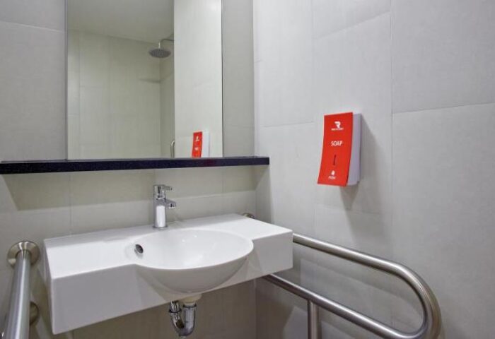 Red Planet Bangkok Surawong gay-friendly hotel bathroom. Sink, mirror, soap dispenser, and handrail. Modern design for gay travelers in Thailand.