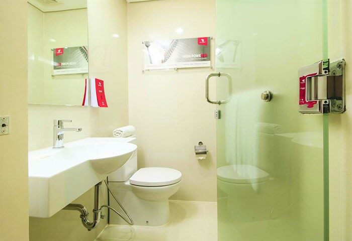 Red Planet Manila Makati gay-friendly hotel bathroom. Features a modern sink, toilet, and shower with glass door. Clean, compact space.