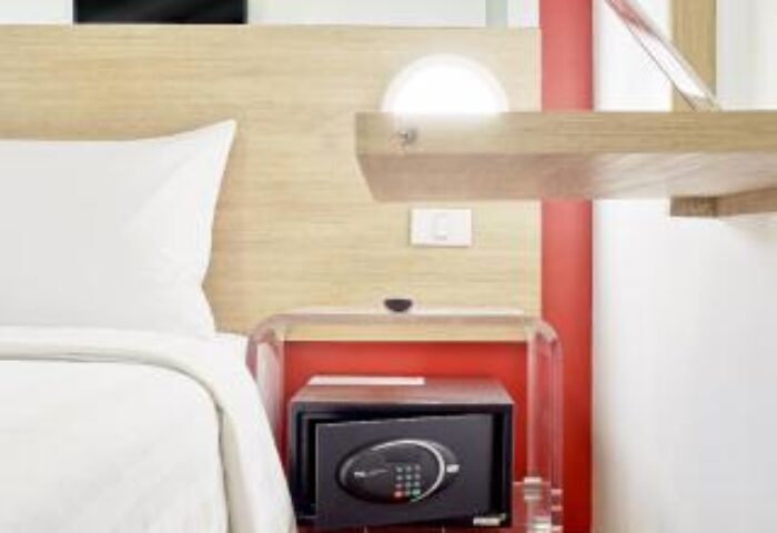Red Planet Manila Makati gay-friendly hotel room interior. Safe box under a clear acrylic table. Modern design, comfortable for gay travelers.