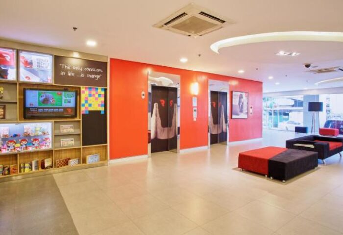 Red Planet Manila Makati lobby. Gay-friendly hotel with orange walls, elevators, & seating. Modern design. A top choice for gay travelers.