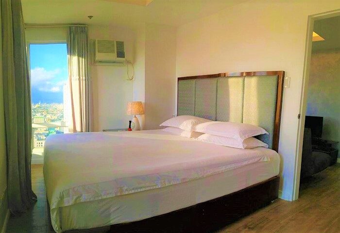 Regency Grand Suites gay-friendly hotel room. King bed with city view. Modern suite for gay travel. Comfortable stay in a well-lit room.