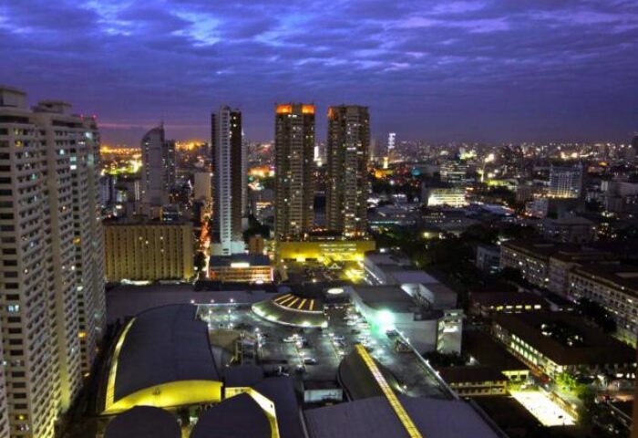 Night view from Regency Grand Suites, a gay-friendly hotel. Cityscape with illuminated skyscrapers and buildings. Perfect for gay travel.