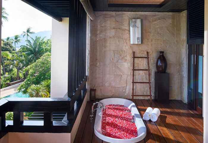 Balcony view at Renaissance Koh Samui Resort & Spa, a gay-friendly hotel. Bathtub filled with rose petals, tropical scenery. #gaytravel