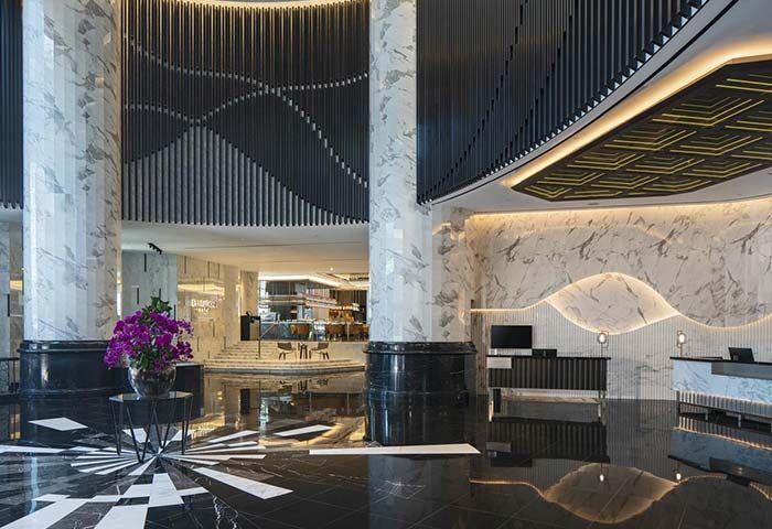 Renaissance Kuala Lumpur Hotel & Convention Centre lobby. Gay-friendly hotel with marble pillars, patterned floor, and modern design elements.
