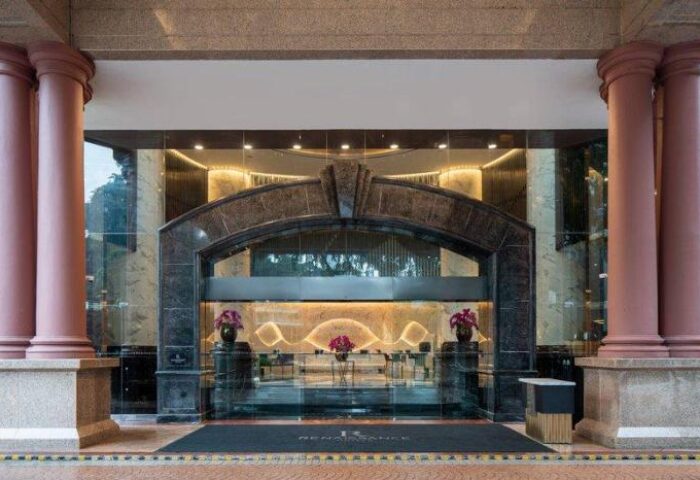 Renaissance Kuala Lumpur Hotel & Convention Centre entrance. Gay-friendly hotel with marble arch, columns, and glass doors. Upscale design.