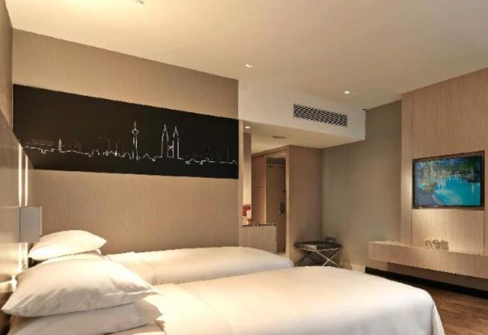 Renaissance Kuala Lumpur Hotel room. Gay-friendly hotel with twin beds, city skyline art, and a TV. Modern design at this convention centre hotel.