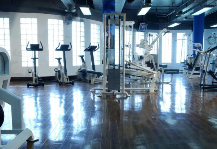 Gym at Renaissance Kuala Lumpur Hotel & Convention Centre. Cardio machines and weightlifting equipment on a shiny wood floor. Gay-friendly hotel.