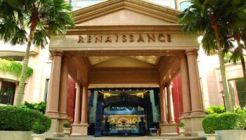 Renaissance Kuala Lumpur Hotel & Convention Centre entrance. Gay-friendly hotel with palm trees. Luxury travel for gay men.