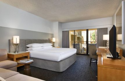 Gay-friendly Renaissance Palm Springs Hotel room. King bed, balcony, desk, and TV. A great stay in Palm Springs for gay men travelers.