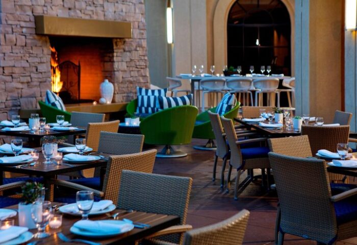 Renaissance Palm Springs Hotel outdoor dining. Gay-friendly hotel with fireplace, tables, and seating. Palm Springs travel for gay men.