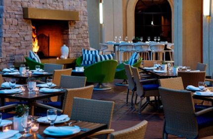 Renaissance Palm Springs Hotel outdoor dining. Gay-friendly hotel with fireplace, tables, and seating. Palm Springs travel for gay men.