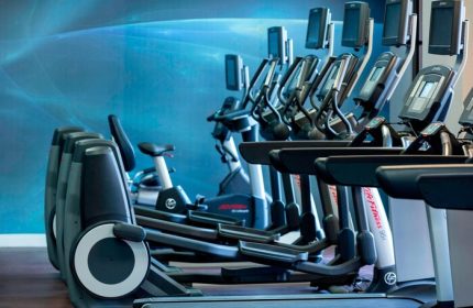 Gay-Friendly Renaissance Palm Springs Hotel gym. Treadmills, ellipticals, and stationary bikes for guests' fitness. Hotel gym with blue wall.