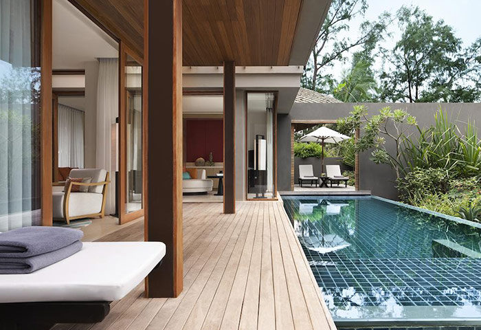 Renaissance Phuket Resort & Spa gay-friendly hotel. Private pool villa with wooden deck, lounge chairs, and lush greenery. Luxury travel.