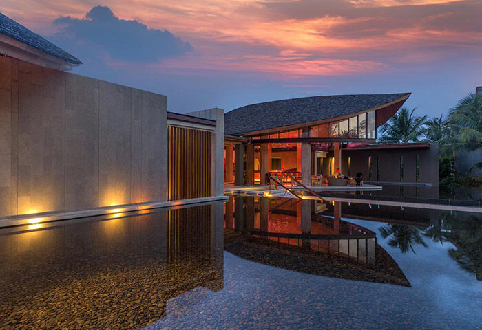 Renaissance Phuket Resort & Spa, a gay-friendly hotel. Exterior view at sunset, reflecting in water. Luxury travel for gay men.