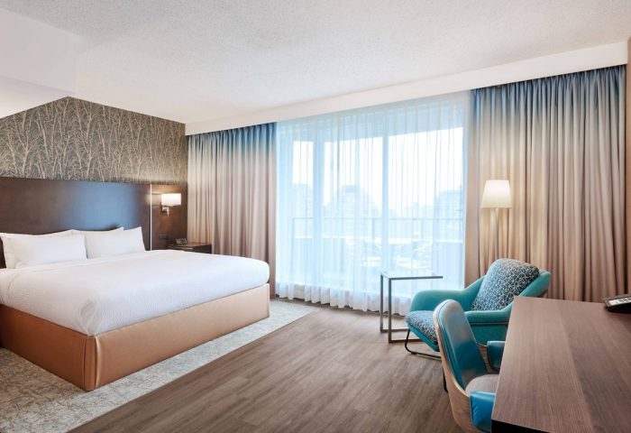 Residence Inn by Marriott Vancouver Downtown room. Gay-friendly hotel with bed, desk, and chairs. Modern decor, light, and airy. Perfect for gay travel.