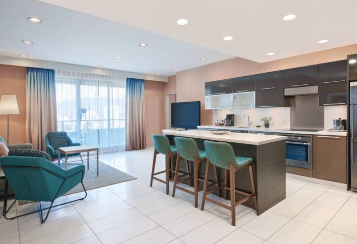 Residence Inn by Marriott Vancouver Downtown suite. Gay-friendly hotel with kitchen, island seating, and lounge area. Modern design.
