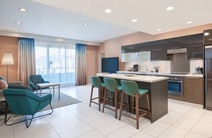 Residence Inn by Marriott Vancouver Downtown suite. Gay-friendly hotel with kitchen, island seating, and lounge area. Modern design.