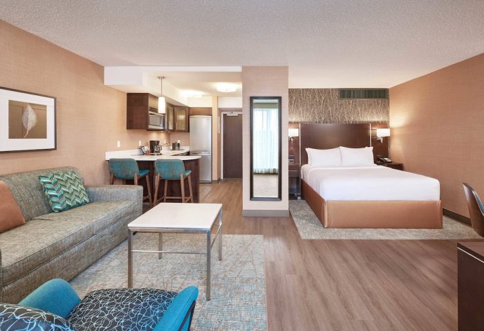 Residence Inn by Marriott Vancouver Downtown suite. Gay-friendly hotel with bed, sofa, kitchen, and modern decor. Perfect for gay travel.