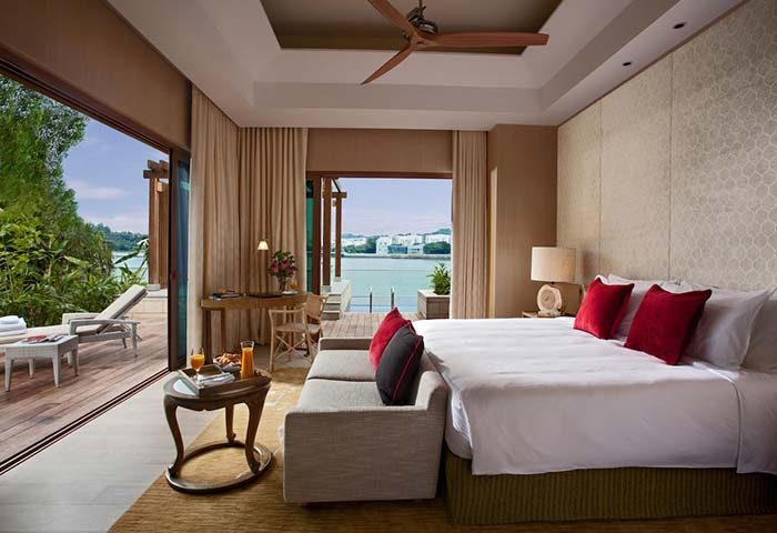 Resorts World Sentosa Beach Villas gay-friendly hotel room. King bed, desk, outdoor deck with lounge chairs. SG Clean Certified.
