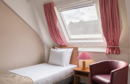 Gay-Friendly Rho Hotel room with single bed, chair, and skylight. A comfortable stay at this gay hotel. Perfect for gay travel in Amsterdam.