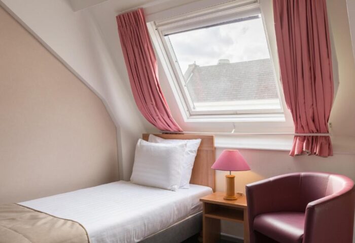 Gay-Friendly Rho Hotel room with single bed, chair, and skylight. A comfortable stay at this gay hotel. Perfect for gay travel in Amsterdam.