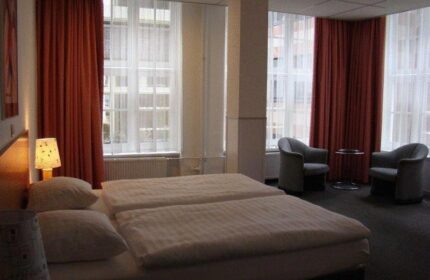 Bedroom at Gay-Friendly Rho Hotel. Room with twin beds, chairs, and large windows. A comfortable choice for gay travelers.