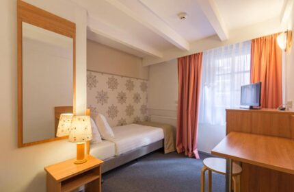 Rho Hotel room interior. Gay-friendly hotel room with bed, desk, TV, and mirror. Comfortable lodging for gay travelers in Amsterdam.