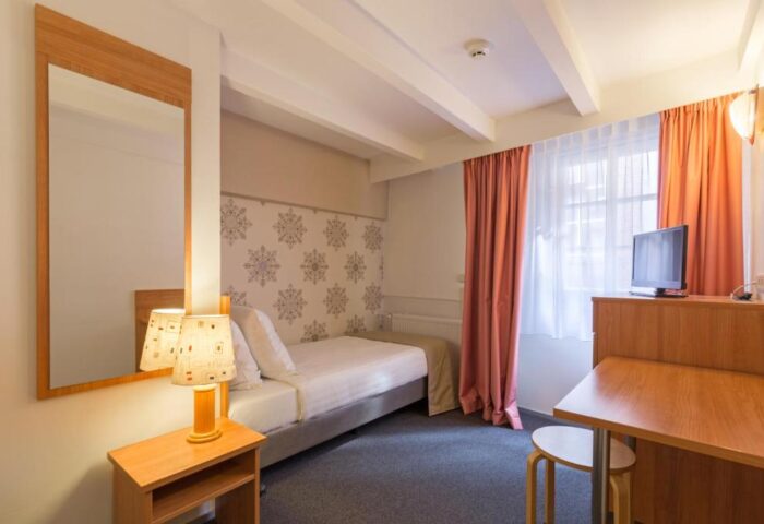 Rho Hotel room interior. Gay-friendly hotel room with bed, desk, TV, and mirror. Comfortable lodging for gay travelers in Amsterdam.