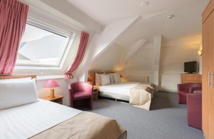 Rho Hotel's gay-friendly lodging: Room view with twin beds, pink accents, and a skylight. Comfortable stay for gay travelers.