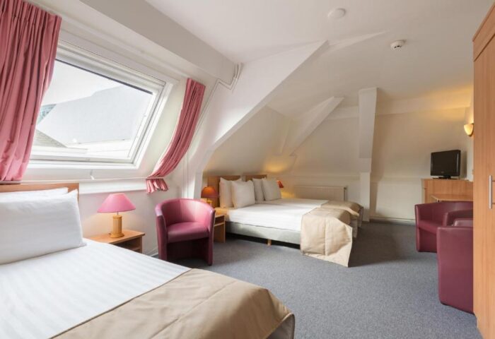Rho Hotel's gay-friendly lodging: Room view with twin beds, pink accents, and a skylight. Comfortable stay for gay travelers.