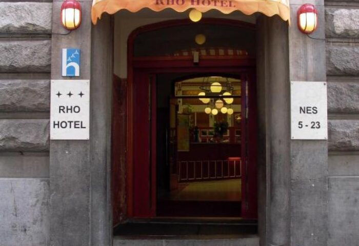 Entrance to Rho Hotel, a gay-friendly hotel in Amsterdam. Striped awning above the door. Hotel entrance with address. Facade of Rho Hotel.