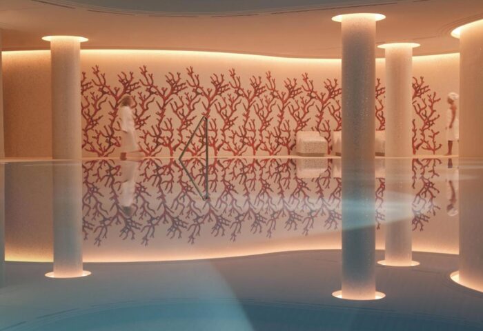 Rocco Forte The Charles Hotel pool, a gay-friendly hotel. Columns rise from the water, reflecting coral art. A luxury spa for gay travelers.