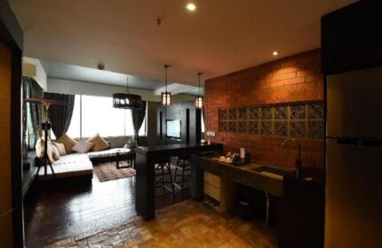 Rose Garden Hotel's gay-friendly suite. Modern kitchen, brick wall, and cozy living area. Perfect for gay travelers seeking comfort.