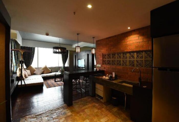 Rose Garden Hotel's gay-friendly suite. Modern kitchen, brick wall, and cozy living area. Perfect for gay travelers seeking comfort.