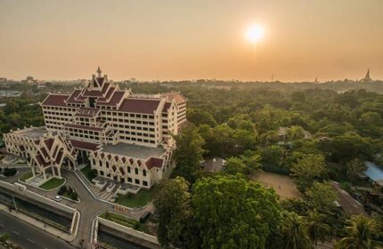 Rose Garden Hotel, a gay-friendly hotel. Exterior view of the hotel with a sunset in the background. A great choice for gay men travelers.