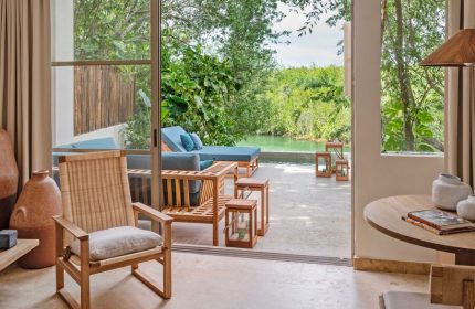 Rosewood Mayakoba gay-friendly hotel suite view. Outdoor seating, pool, and lush greenery. Luxury travel for gay men in Riviera Maya.