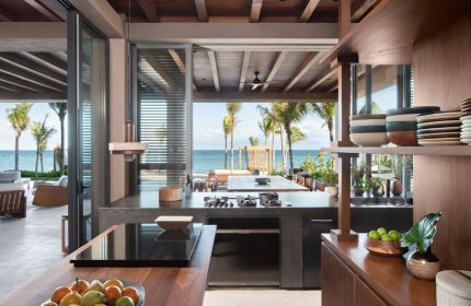 Rosewood Mayakoba gay-friendly hotel kitchen with ocean view. Luxury resort with modern design, palm trees, and outdoor dining.