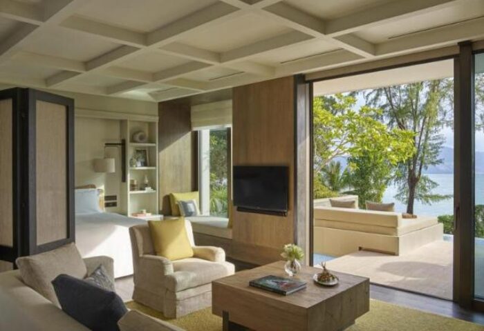 Rosewood Phuket gay-friendly hotel suite with ocean view. Luxurious room interior with bed, seating area, and balcony. Perfect for gay travel.