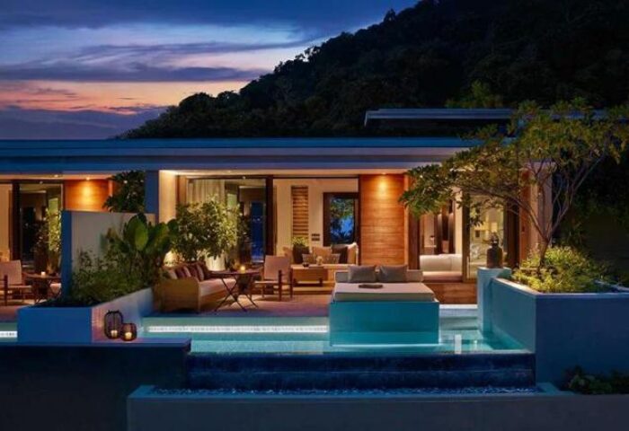 Rosewood Phuket gay-friendly hotel at dusk. Luxury villa with private pool and outdoor lounge area. Ideal for gay men's travel in Thailand.