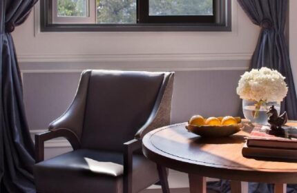 Rosewood Yangon gay-friendly hotel room. Pet-friendly with chair, table, fruit, flowers, and decor. Luxury travel for gay men in Myanmar.