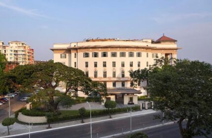 Rosewood Yangon, a gay-friendly and pet-friendly hotel. Exterior view of the luxury hotel in Yangon, Myanmar, with trees and street.