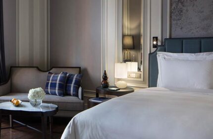 Rosewood Yangon gay-friendly hotel room. Pet-friendly suite with bed, couch, and table. Elegant decor for LGBTQ+ travelers in Yangon.