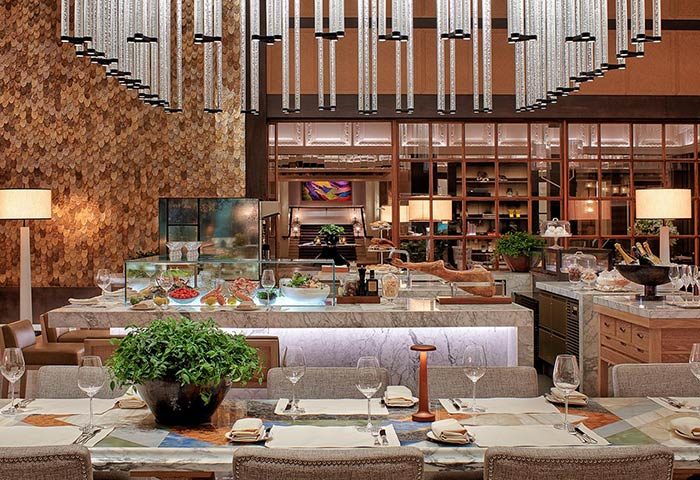 Rosewood Yangon's dining area. Gay-friendly, pet-friendly hotel features a buffet, stylish lighting, and elegant table settings.