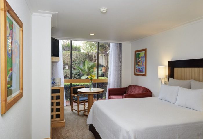 Hotel Royal Reforma gay-friendly room. Features a bed, sofa, table, & garden view. Ideal Zona stay for gay travelers.