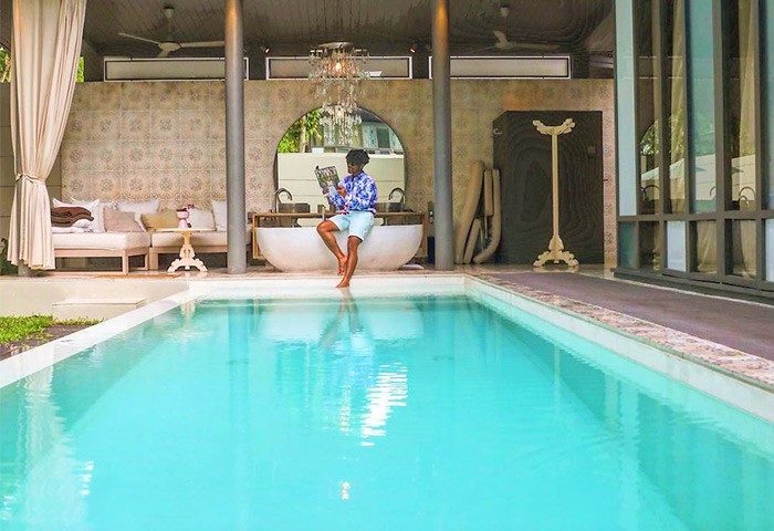 Gay-Friendly SALA Phuket Mai Khao Beach Resort: Man reading by the pool. Luxury hotel, ideal for gay travelers seeking relaxation.