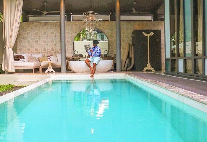 Gay-Friendly SALA Phuket Mai Khao Beach Resort: Man reading by the pool. Luxury hotel, ideal for gay travelers seeking relaxation.