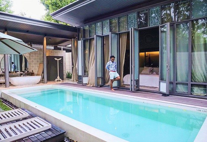 Man at SALA Phuket Mai Khao Beach Resort villa with pool. Gay-friendly hotel offers luxury accommodations for gay men travelers.