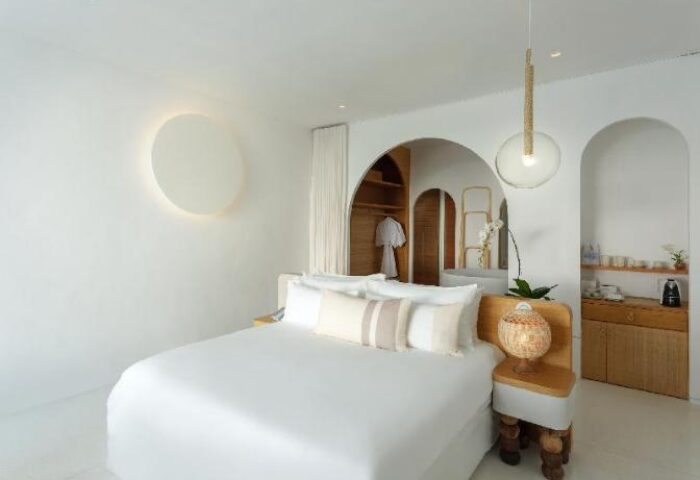 SALA Samui Chaweng Beach gay-friendly hotel room. Minimalist white decor, king bed, arched doorways, closet, and modern lighting. Ideal for gay travel.